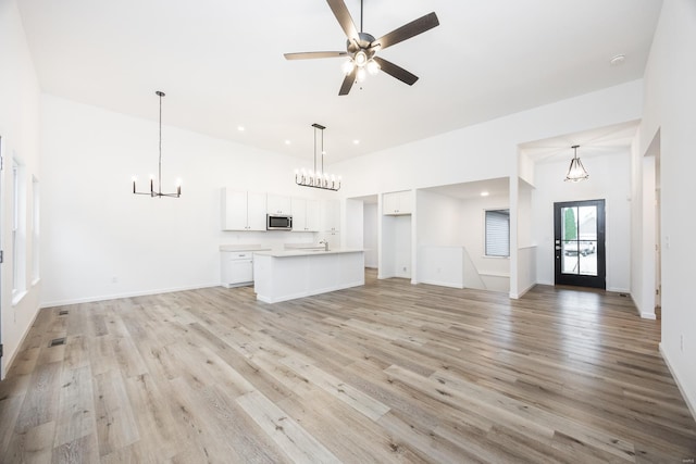 unfurnished living room featuring french doors, light hardwood / wood-style floors, and ceiling fan