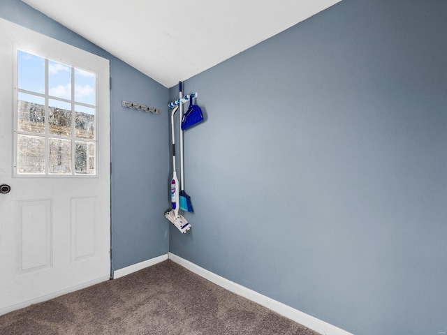 doorway to outside with carpet flooring and vaulted ceiling