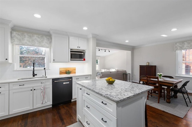 kitchen featuring sink, dishwasher, white cabinetry, tasteful backsplash, and a kitchen island