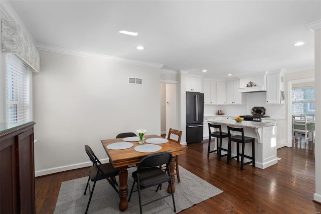 dining space featuring dark wood-type flooring and ornamental molding