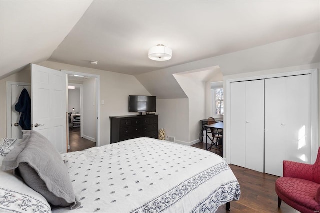 bedroom featuring a closet, vaulted ceiling, and dark hardwood / wood-style floors