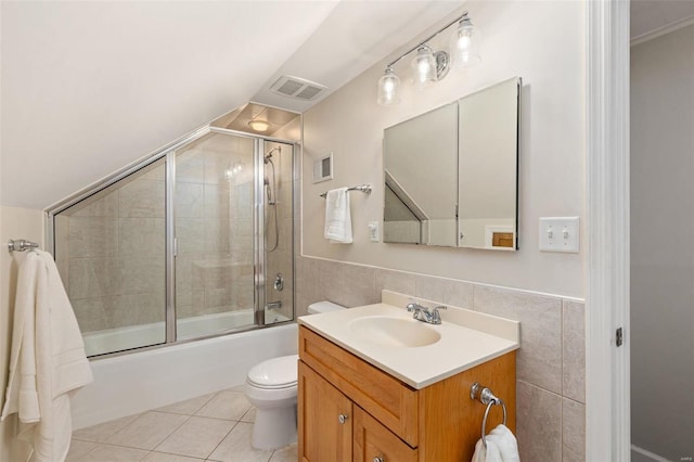 full bathroom featuring tile walls, enclosed tub / shower combo, vanity, toilet, and tile patterned floors