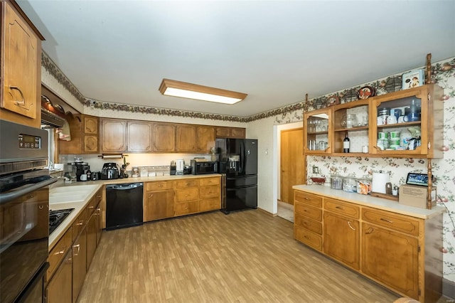 kitchen featuring sink, black appliances, and light wood-type flooring