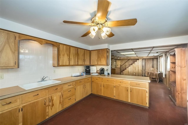 kitchen featuring kitchen peninsula, backsplash, ceiling fan, and sink