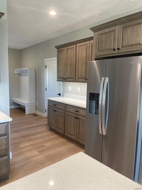 kitchen with stainless steel refrigerator with ice dispenser and light wood-type flooring