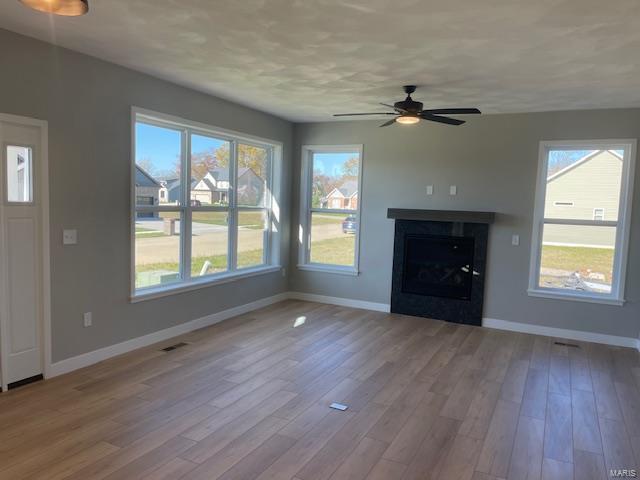 unfurnished living room featuring light wood-type flooring and ceiling fan