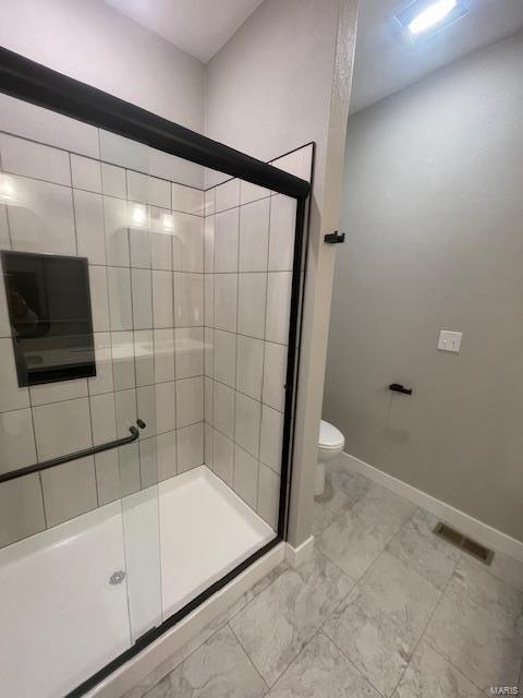 bathroom with walk in shower and toilet