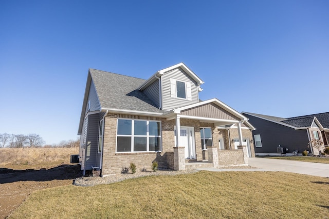 craftsman-style house with central air condition unit, brick siding, concrete driveway, roof with shingles, and a front yard