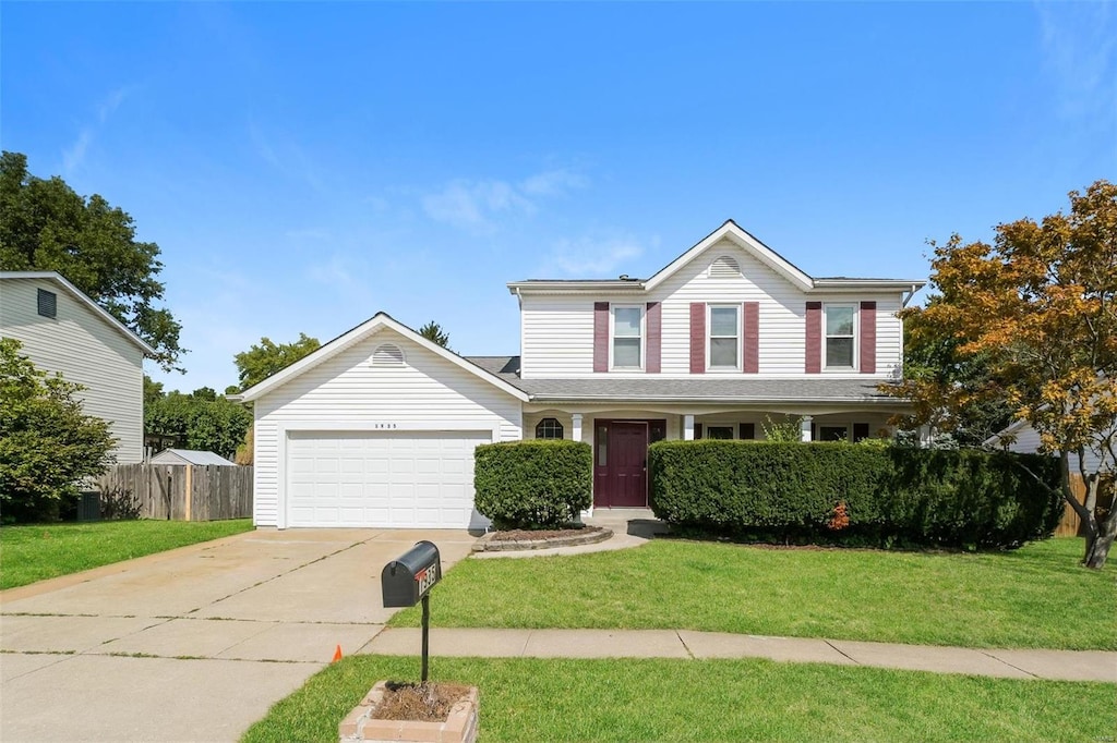 view of property featuring a garage and a front lawn