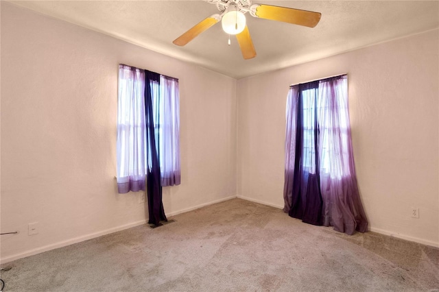 unfurnished room with light colored carpet and ceiling fan