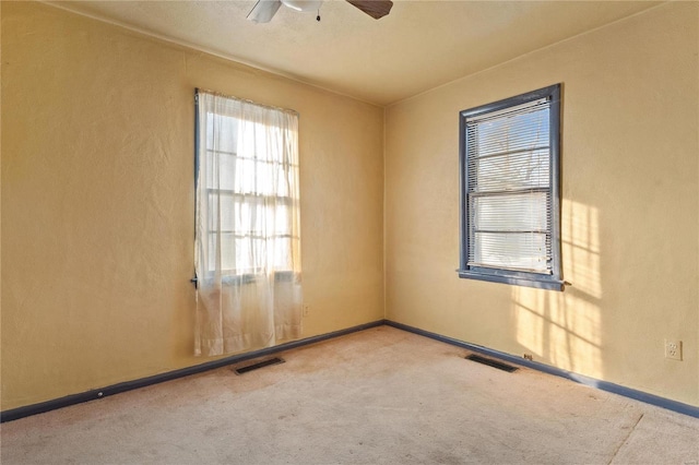 carpeted spare room with ceiling fan