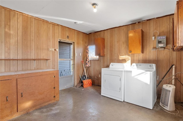 clothes washing area with cabinets, separate washer and dryer, and a workshop area