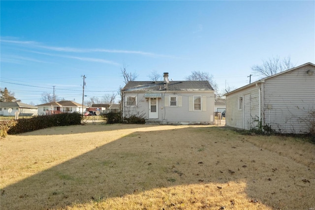 rear view of house featuring a yard