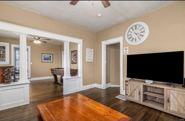 living room with dark hardwood / wood-style flooring and ornate columns