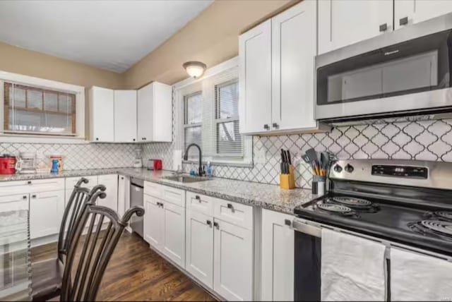 kitchen with appliances with stainless steel finishes, white cabinetry, and sink