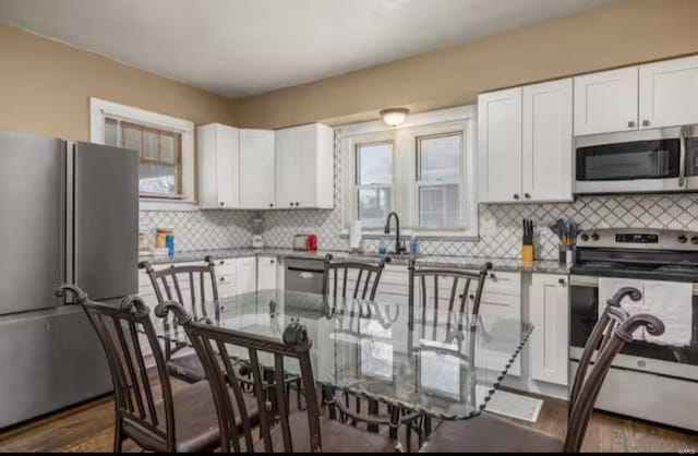 kitchen featuring white cabinetry, backsplash, and appliances with stainless steel finishes