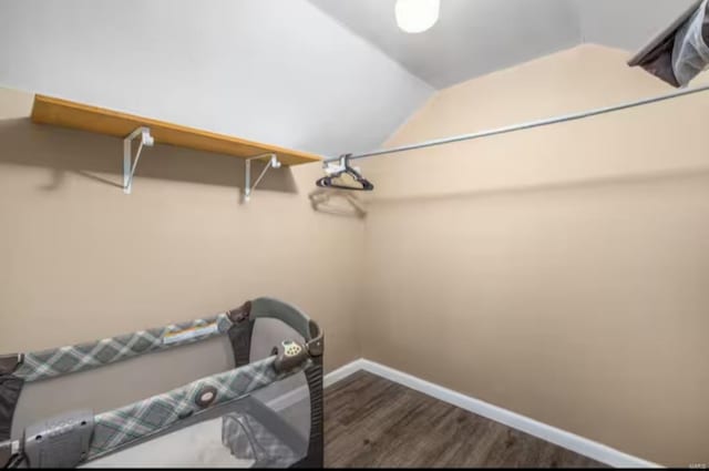 walk in closet featuring dark hardwood / wood-style flooring and vaulted ceiling