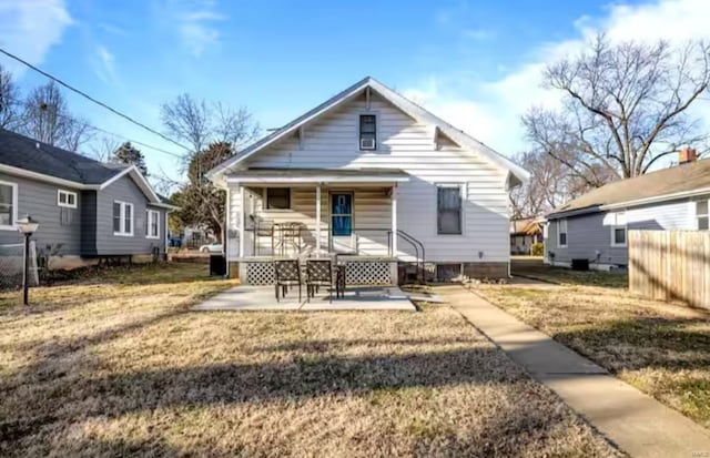 rear view of property featuring a porch and a lawn