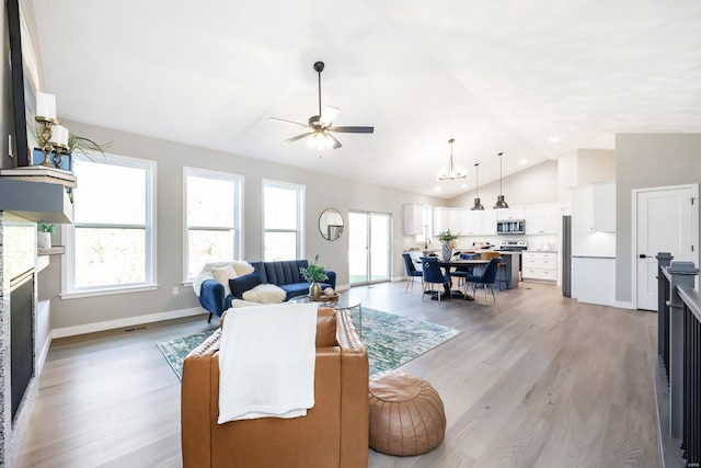 living room featuring ceiling fan, vaulted ceiling, and light wood-type flooring