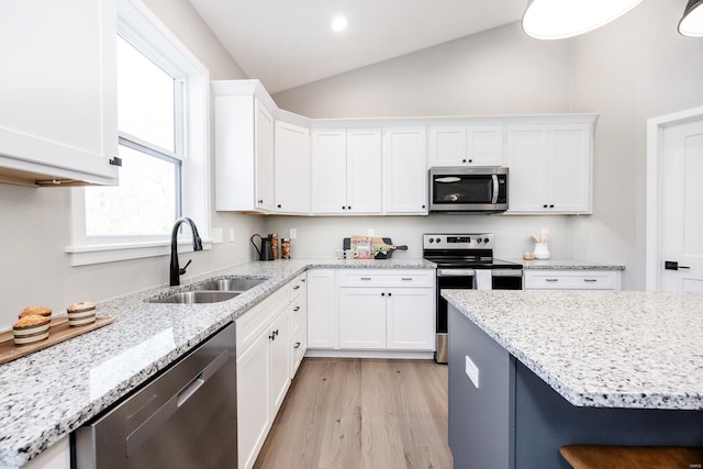 kitchen featuring lofted ceiling, sink, light hardwood / wood-style flooring, appliances with stainless steel finishes, and white cabinetry