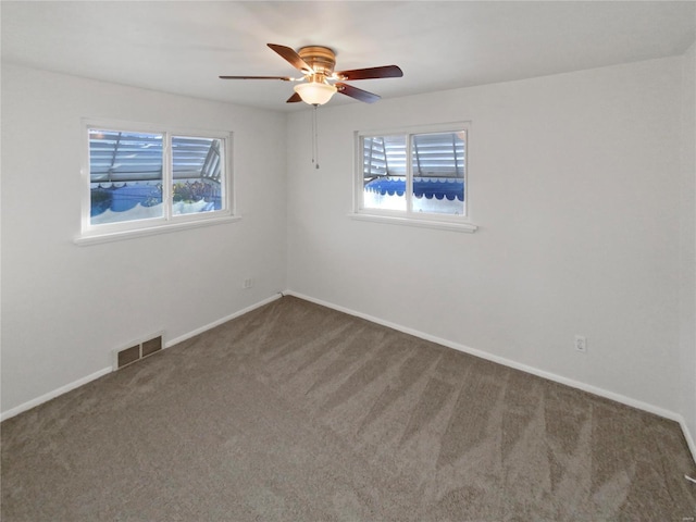 carpeted empty room with a wealth of natural light and ceiling fan