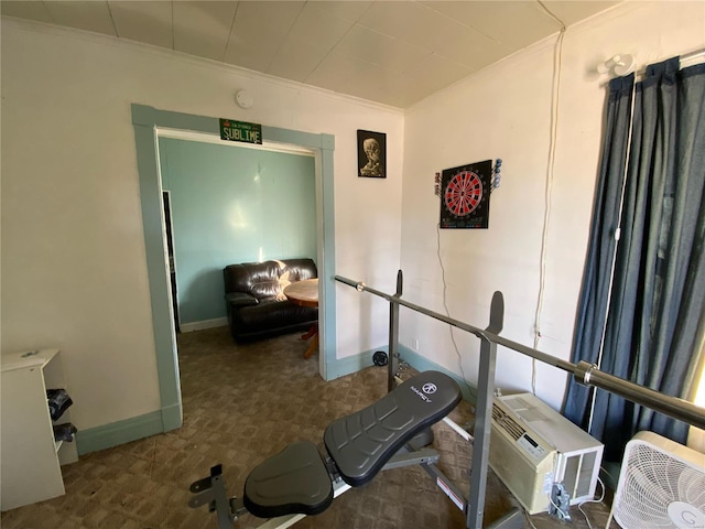 workout area with ornamental molding, dark colored carpet, and baseboards