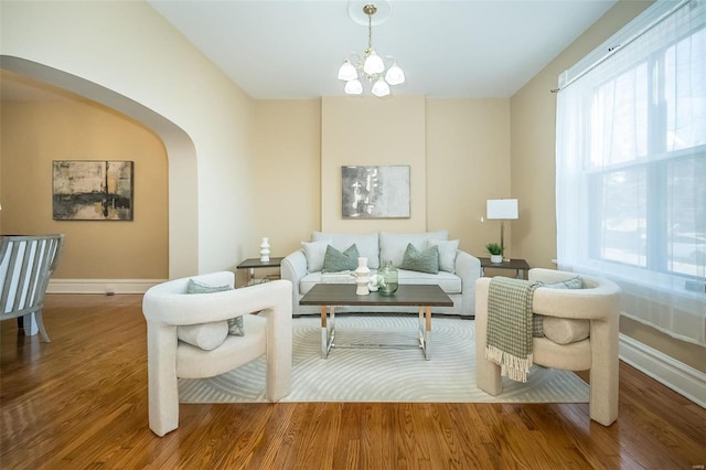 sitting room featuring wood-type flooring and an inviting chandelier