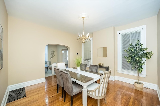 dining room featuring light wood-type flooring and a notable chandelier