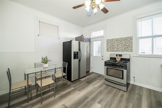 kitchen featuring decorative backsplash, dark hardwood / wood-style flooring, stainless steel appliances, ceiling fan, and crown molding