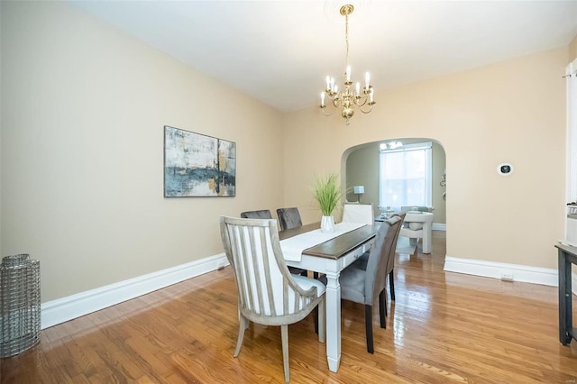 dining room with light hardwood / wood-style flooring and a notable chandelier