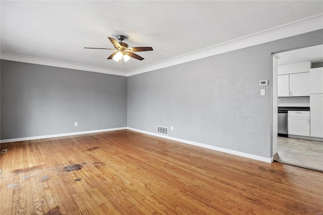 empty room with light wood-type flooring, ceiling fan, and crown molding