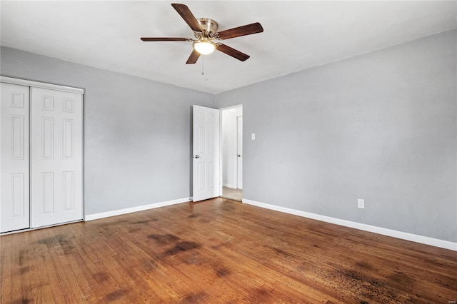 unfurnished bedroom featuring ceiling fan, wood-type flooring, and a closet