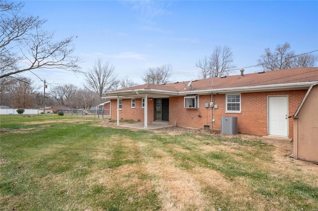 back of property with a lawn, a patio area, and central AC