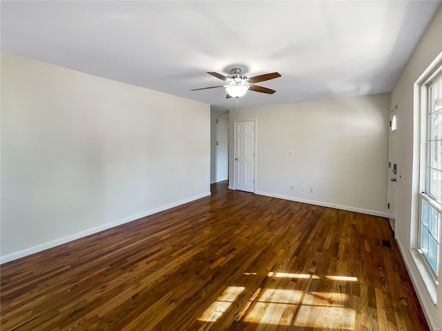 unfurnished room featuring ceiling fan, a healthy amount of sunlight, and dark hardwood / wood-style flooring