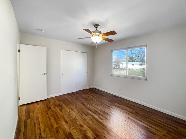 unfurnished bedroom featuring a closet, hardwood / wood-style flooring, and ceiling fan