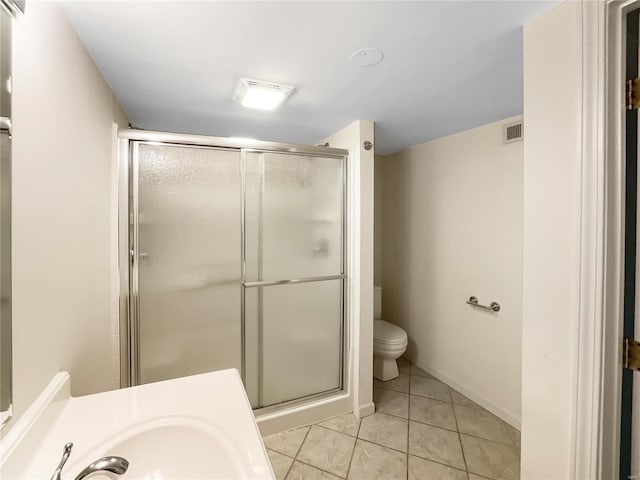 bathroom with tile patterned floors, toilet, sink, and walk in shower