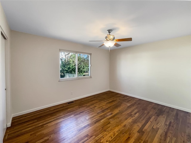 spare room featuring ceiling fan and dark wood-type flooring