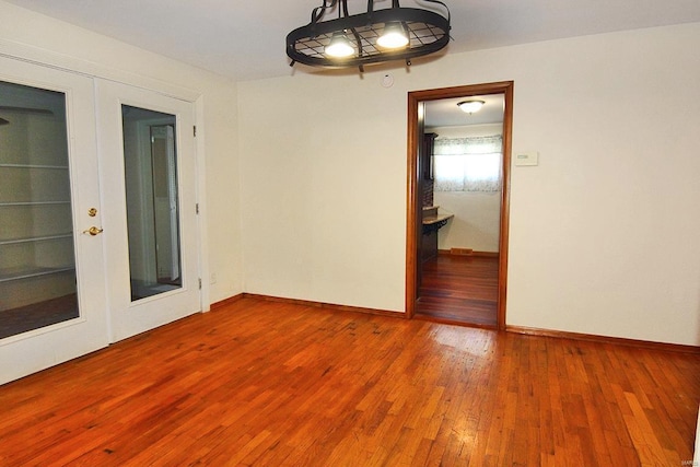 spare room featuring french doors and wood-type flooring