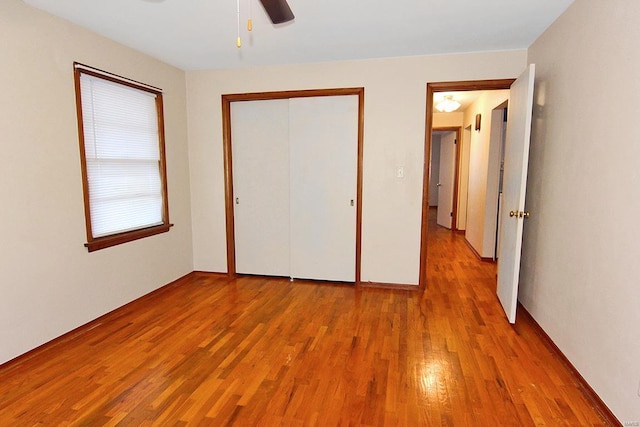 unfurnished bedroom with ceiling fan, a closet, and light hardwood / wood-style flooring