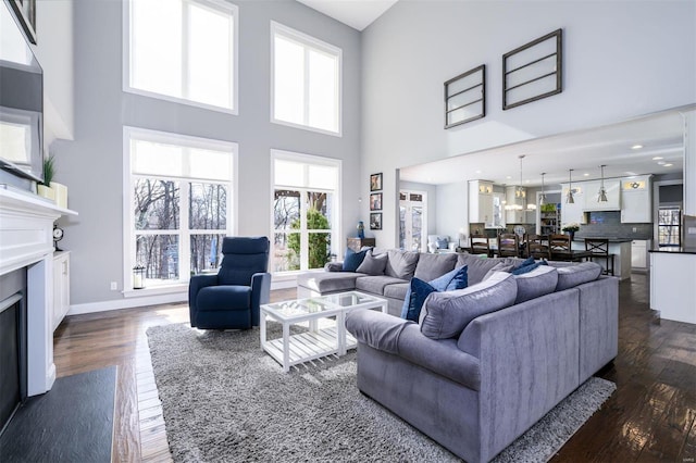 living room with dark wood-type flooring and a towering ceiling