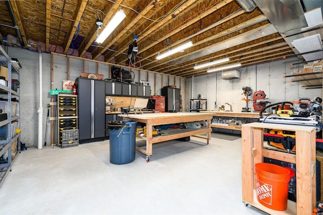 basement with stainless steel fridge and a workshop area