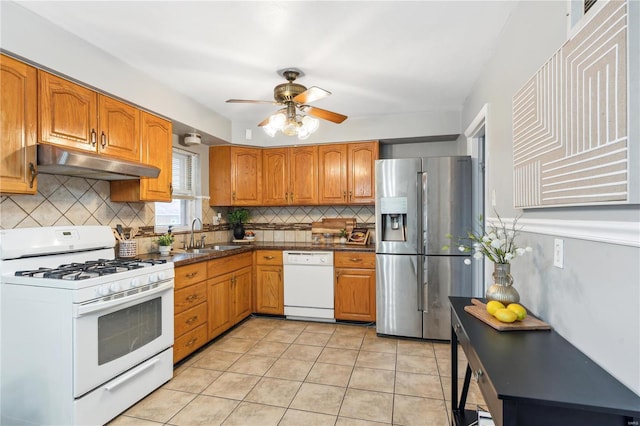 kitchen with decorative backsplash, light tile patterned floors, white appliances, and sink