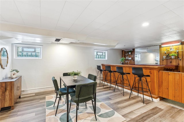 dining room featuring light wood-type flooring and bar