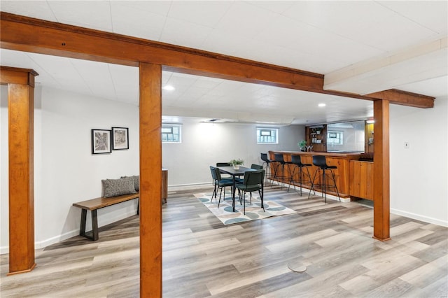 dining space featuring bar and light hardwood / wood-style flooring