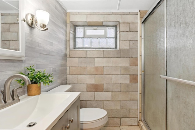 bathroom featuring tile patterned flooring, vanity, an enclosed shower, and toilet