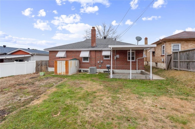 rear view of house featuring a lawn and cooling unit