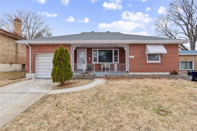 single story home with covered porch, a garage, and a front yard