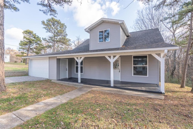 view of front of property with covered porch, a front yard, and a garage