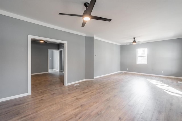 spare room featuring ceiling fan, light wood-type flooring, and crown molding