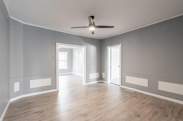 empty room with ceiling fan, light hardwood / wood-style floors, and ornamental molding